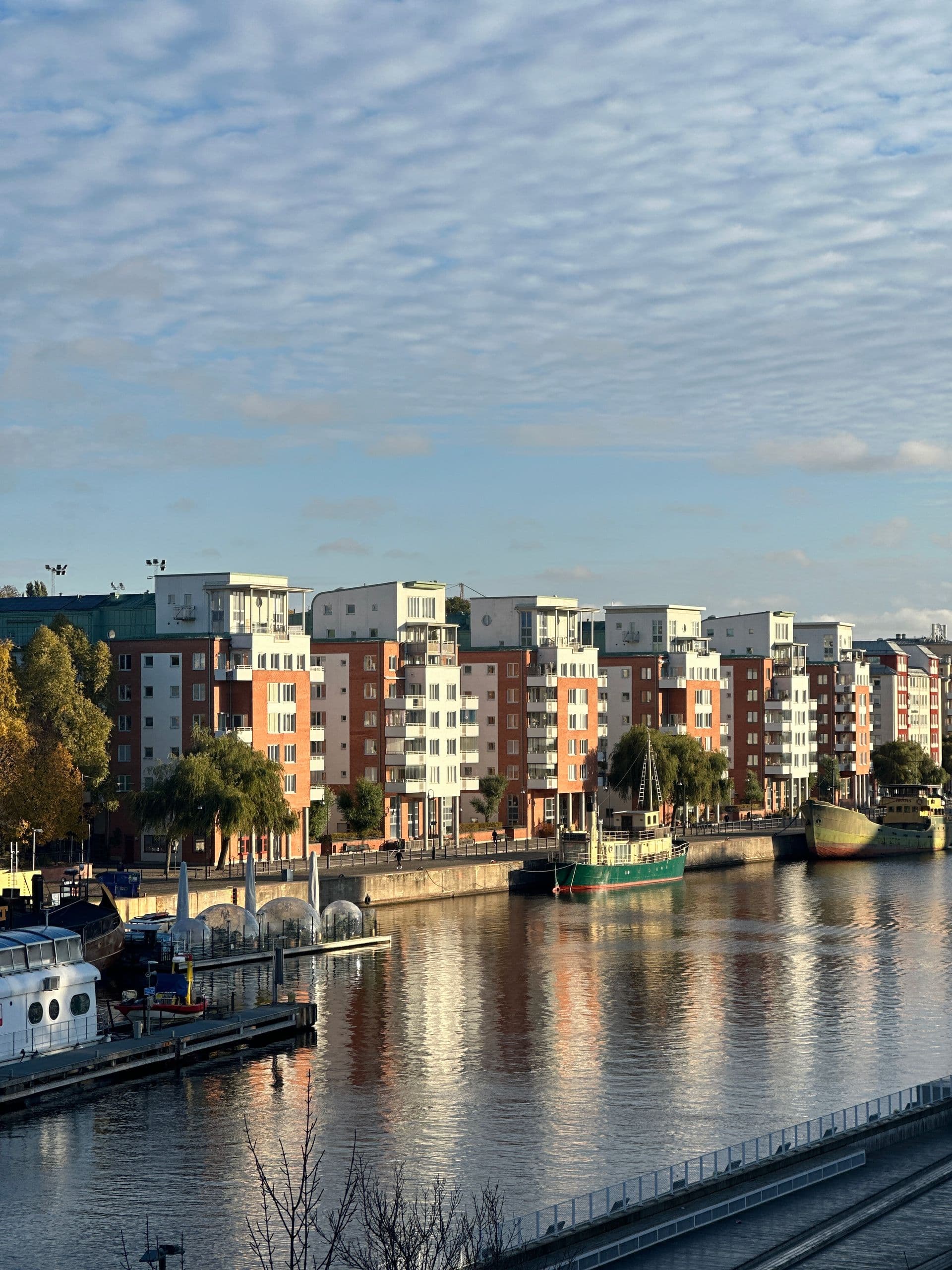 Brick and white apartment blocks along the water in Stockholm, in autumn sun